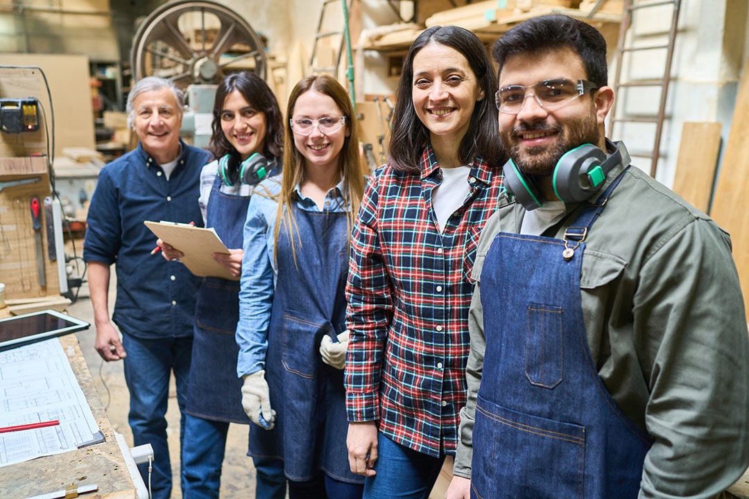 Team of lumberyard workers smiling in a bustling lumberyard